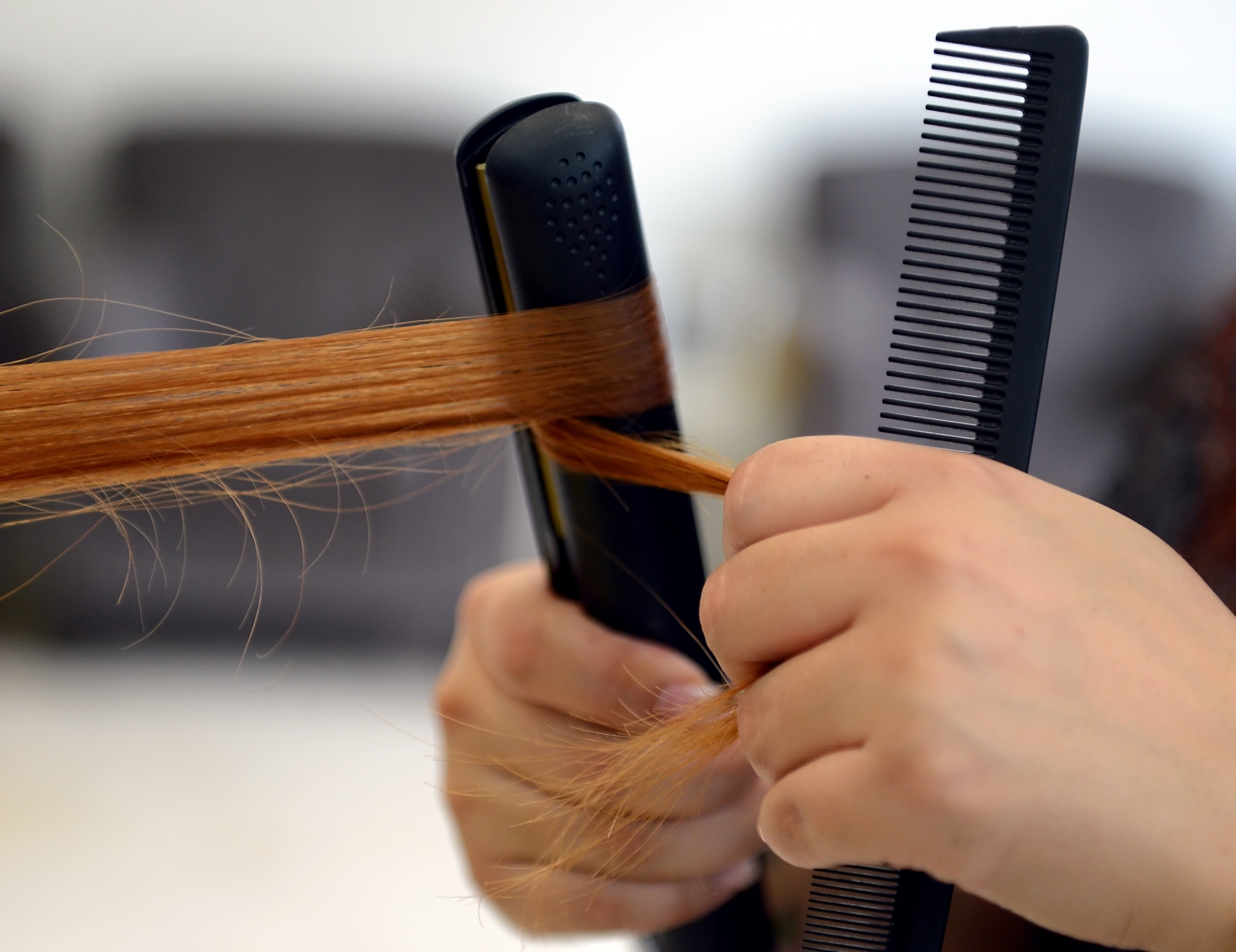 Hairdresser Arzu uses a hair straightene