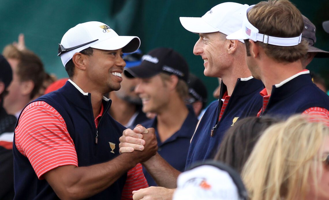 Tiger Woods of the U.S. shakes hands with teammate Jim Furyk after Woods clinched the Presidents Cup with a 4-and-3 victory over Aaron Baddeley.Tiger Woods of the U.S. shakes hands with teammate Jim Furyk after Woods clinched the Presidents Cup with a 4-and-3 victory over Aaron Baddeley.