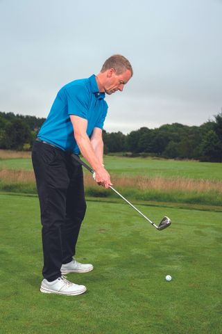Golf Monthly Top 50 Coach demonstrating an inside takeaway drill involving using your stomach and the butt of the club