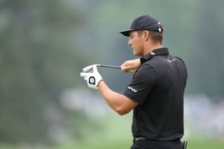 Bryson DeChambeau looks at his wedge