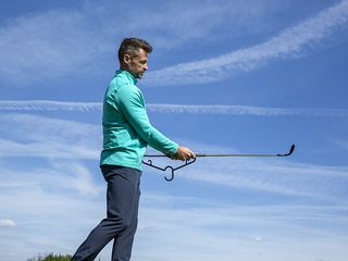 Short Game Specialist Coach James Ridyard demonstrating the correct finish position using the training aid, a coat hanger.