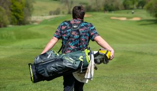 A golfer walks with the Big Max Aqua Eight G Stand Bag on his back