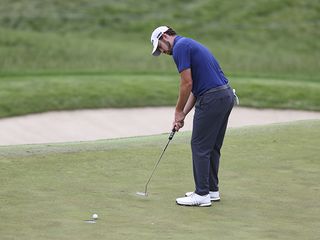 Patrick Cantlay hitting a short putt towards the hole