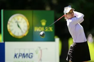 Sarah Schmelzel strikes a driver and watches her tee shot