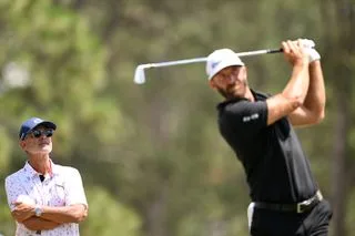 Claude Harmon III watching Dustin Johnson play a shot