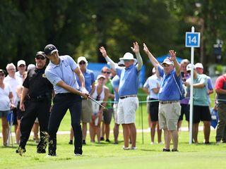 Jordan Spieth hitting a chip shot in front of the gallery at a PGA Tour event