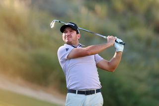 Alejandro Tosti strikes an iron shot and watches its flight in the air