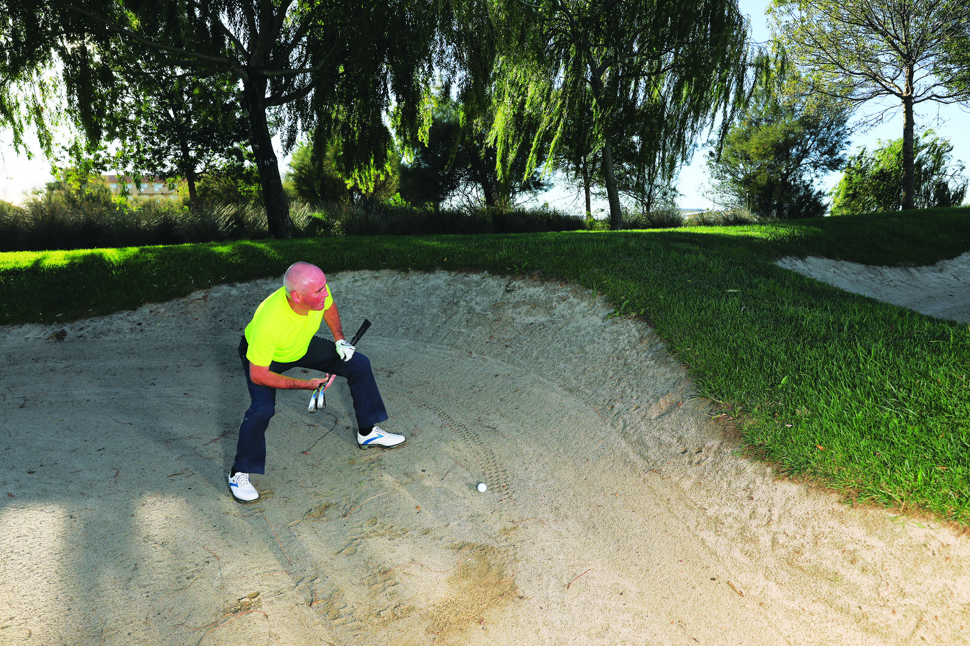 Keith Williams in the sand assessing his options prior to playing a long bunker shot