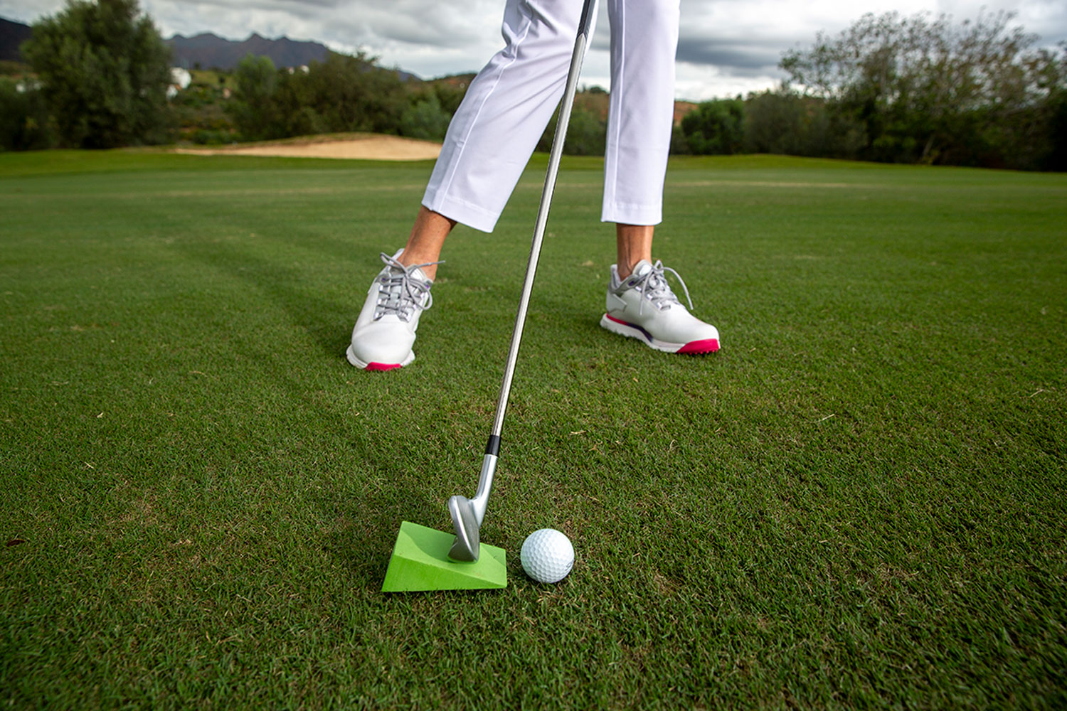 A training aid demonstrating the correct downward angle of attack for an iron shot