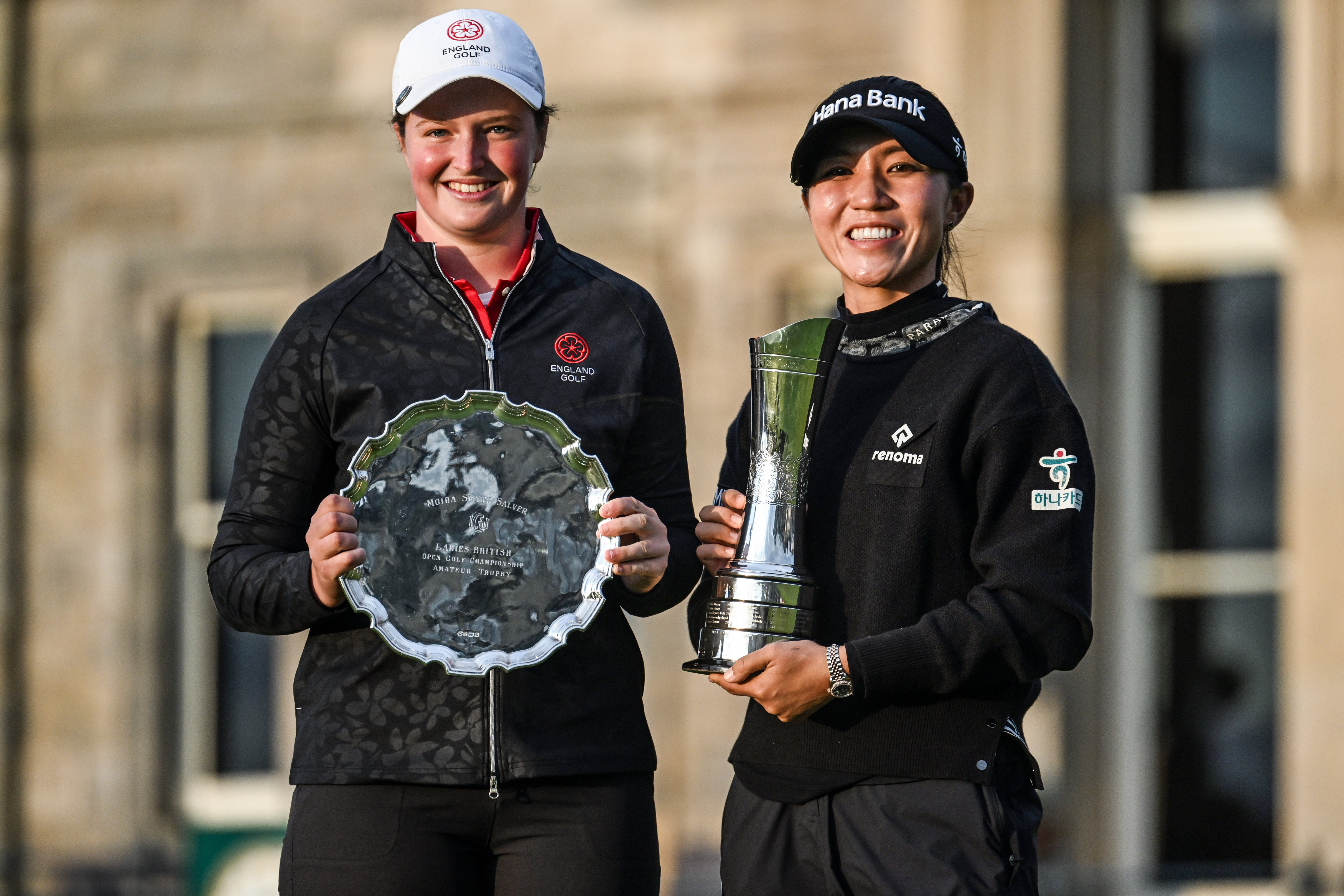 Lottie Woad holds the Smyth Salver next to Lydia Ko holding the AIG Women's Open trophy