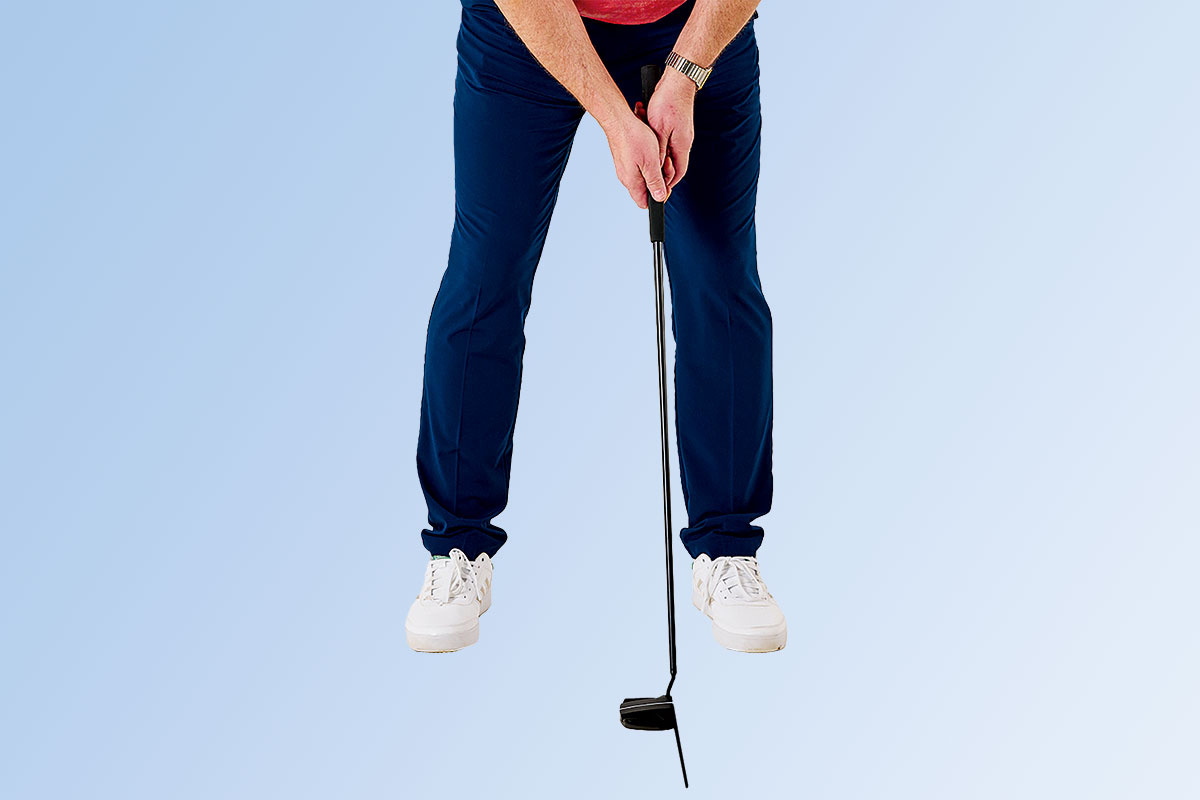 Close up of Russell Covey holding a putter with a coffee stirrer attached to the face, with the intention of understanding the angle of the clubface at impact