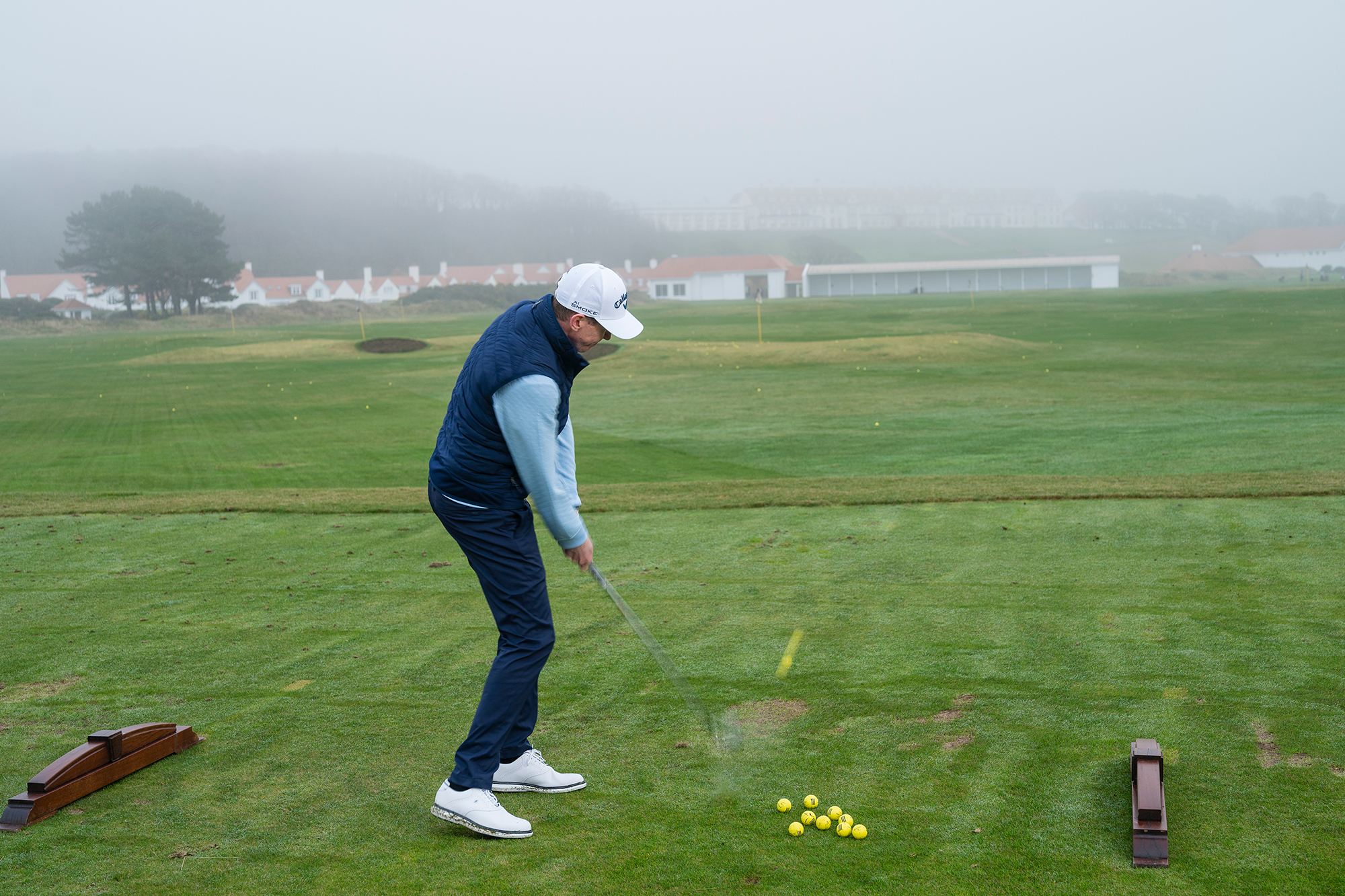 Ben Emerson 'machine-gunning' through golf balls, which is a common amateur mistake, on the driving range at Trump Turnberry