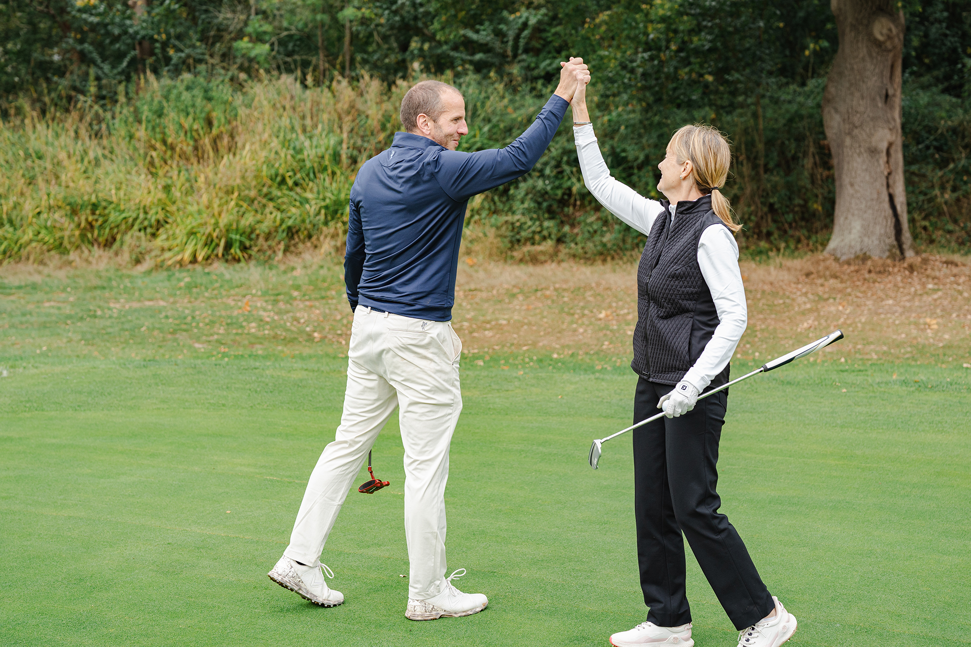 Dave Taylor and Alison Root celebrating on the green by high-fiving